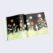 Open book spread. Both pages feature illustration of a small girl in a large open flower field against a black sky. "A place to dream..." is written on the left page.
