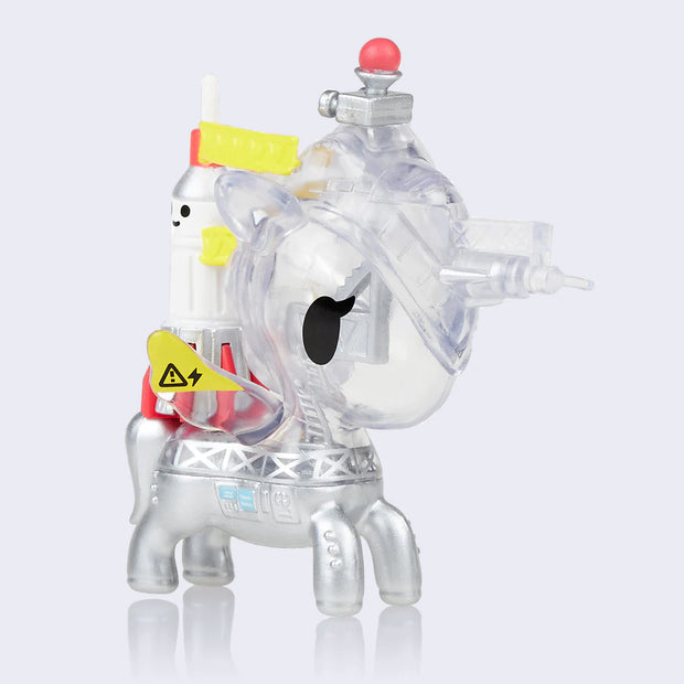 Houston Unicorno, a clear unicorn designed to remember a rocket launching site, with a smiling white rocket on its back with red base and yellow color accents.