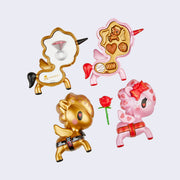 2 vinyl unicorno figures cross section, the gold one with a ring inside of it, the pink unicorn is open like a box of chocolates.