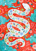 Paper cut art of a white snake with various flowers and leaves on its body in a pattern. Background is bright red with teal blue clouds and cut paper leaves and flowers.