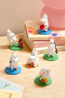 6 Moomin character figurines, all doing different activities such as painting, chopping wood, reading, playing drums, etc.