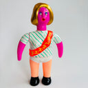 Colorful toy figure with a striped shirt and red sash on a light gray background