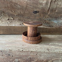 Spool shaped wooden object with a wooden ring around it.