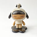 A ceramic sculpture of a girl wearing a hooded mini dress with dog ears. Atop her head is a small dog, matching colors with her outfit.