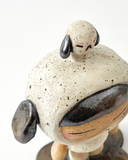A ceramic sculpture of a girl wearing a hooded mini dress with dog ears. Atop her head is a small dog, matching colors with her outfit.