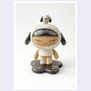 A ceramic figurine of a stylized child in a speckled cream-colored outfit with a hood with dog ears, standing on a dark gray flower-like base, with a small dog figure on top of her head, photographed against a white background.