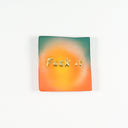 Square shaped ceramic tile with a bright yellow aura coloring with orange and green gradient around the corners. The middle has "fuck it" written in gold font.