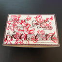 Box of Littlejohn's Candies with decorative design on a dark background