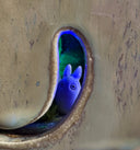 View from the inside of the ceramic cube, with a curved viewing slot. Inside is a small white chibi Totoro.