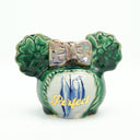 Ceramic sculpture of a head shape without a face but with hair - done up in 2 buns shaped like flowers with a pink bow. Text reads "not perfect" where the face would be in drippy blue font and gold font.