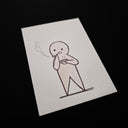 A minimalist line-art work on a white rectangular card, showing a simple stick-figure character smoking with a small puff of smoke. The card is photographed at an angle against a solid black background.