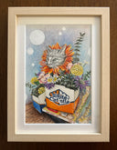 Colored pencil illustration of a gray cat sitting among a vibrant bouquet of flowers and greenery which are held within a White Castle box. It sits atop of an issue of Giant Robot magazine. Piece is framed.