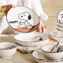 Set of bowls and plates with Snoopy graphics on it.