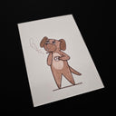 A white rectangular art card featuring a hand-drawn brown cartoon dog standing and holding a small cup, smoking a cigarette  photographed against a black background.