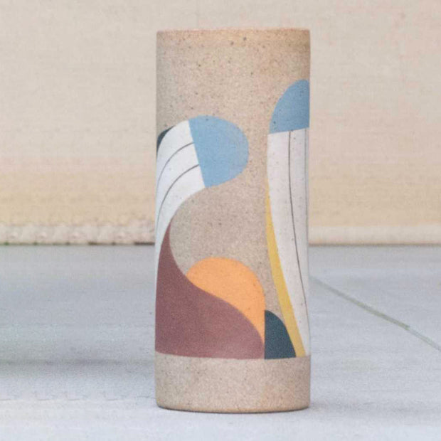 Ceramic vase without any curvature. It is painted in earth tones: burgundy, blue, white and yellow and consists of geometric shapes.