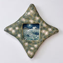 A ceramic star-shaped frame with a textured green and beige glazed border and a central square inset illustration depicting a moonlit scene with a horse and girls running alongside.