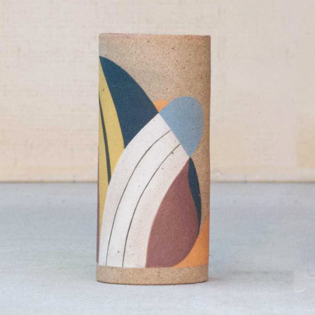 Ceramic vase without any curvature. It is painted in earth tones: burgundy, blue, white and yellow and consists of geometric shapes.