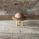 Wooden sculpture of a smooth UFO space craft, up on 3 wooden dowels like legs of the craft.