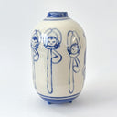 A small ceramic vase with a rounded body, narrow neck, and short feet, decorated with blue line drawings of stylized figures on an off-white glazed background.