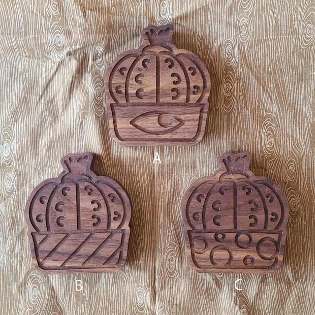 3 die cute wooden bottle openers, shaped like peyote cacti. Each have a different pot design: eye, stripes or bubbles.