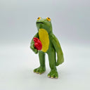 Green frog ceramic figurine holding a red heart on a white background