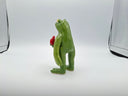 Green frog figurine holding a red heart on a white background