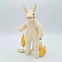 White devil ceramic figure with orange flames on its sides.