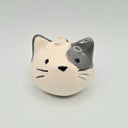 Cat-shaped ceramic ornament on a light gray background