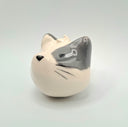 Ceramic cat-shaped object with a gray face on a light gray background