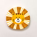 Flat clay face sculpture of an orange lion with a round, geometric patterned mane.