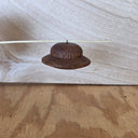 A small rustic brown wooden UFO, with a small wire loop.