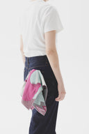 Person standing with a colorful patterned cloth tucked into their back pocket.