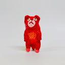 Small clay sculpture of a fluorescent red dog standing on 2 legs.