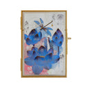 Illustration on white paper of several blue lotus flowers, with a dragon fly hovering over one. Background has graphite flowers and pink accent coloring.