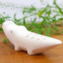 Wooden figurine of a crocodile with a cute, smiling face.