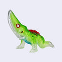 A small translucent green kaiju toy figurine with a red spiked back, a red gem on its head, and clear transparent claws and tail, shown against a light gray background.
