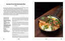 Fried fish shakshuka-style dish with recipe text on a magazine page.