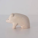 White wood figurine of a pig with a cute smile.