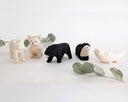 Set of small animal figurines on a white background with green leaves