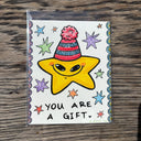Illustration of a cartoon star character wearing a red beanie with text that reads "you are a gift"