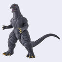 A Godzilla action figure shown standing in a dynamic pose against a plain light gray background. The figure is primarily dark gray with small yellow accents on the claws and mouth details.