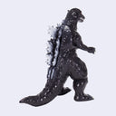 A Godzilla toy figure in a walking pose, featuring a textured black body with gray and white spines, set against a plain light gray background.