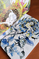 Close up of a book interior, with 2 full bleed pages of illustrations of stylized characters in nature fantasy settings.