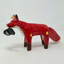 Ceramic sculpture of a red fox with a large fluffy tail and black paws. It holds a cap in its mouth, white and black with a Big Boss Robot logo on it. Small yellow flames come off of the fox's body.