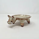 Ceramic plate or very shallow vessel, with a boar's head in the front and 4 legs that act as stands for the plate, attached. 