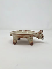 Ceramic plate or very shallow vessel, with a boar's head in the front and 4 legs that act as stands for the plate, attached. 