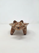 Ceramic plate or very shallow vessel, with a brown raccoon head in the front and 4 legs that act as stands for the vessel, attached. It has a fluffy, long tail.