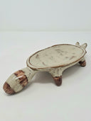 Ceramic vessel like a shallow plate with 4 legs and a raccoon head at the front of the plate.