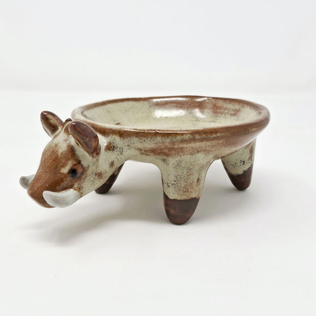 Ceramic plate or very shallow vessel, with a boar's head in the front and 4 legs that act as stands for the plate, attached. 