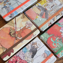 Set of colorful notebooks with illustrated covers on a wooden surface